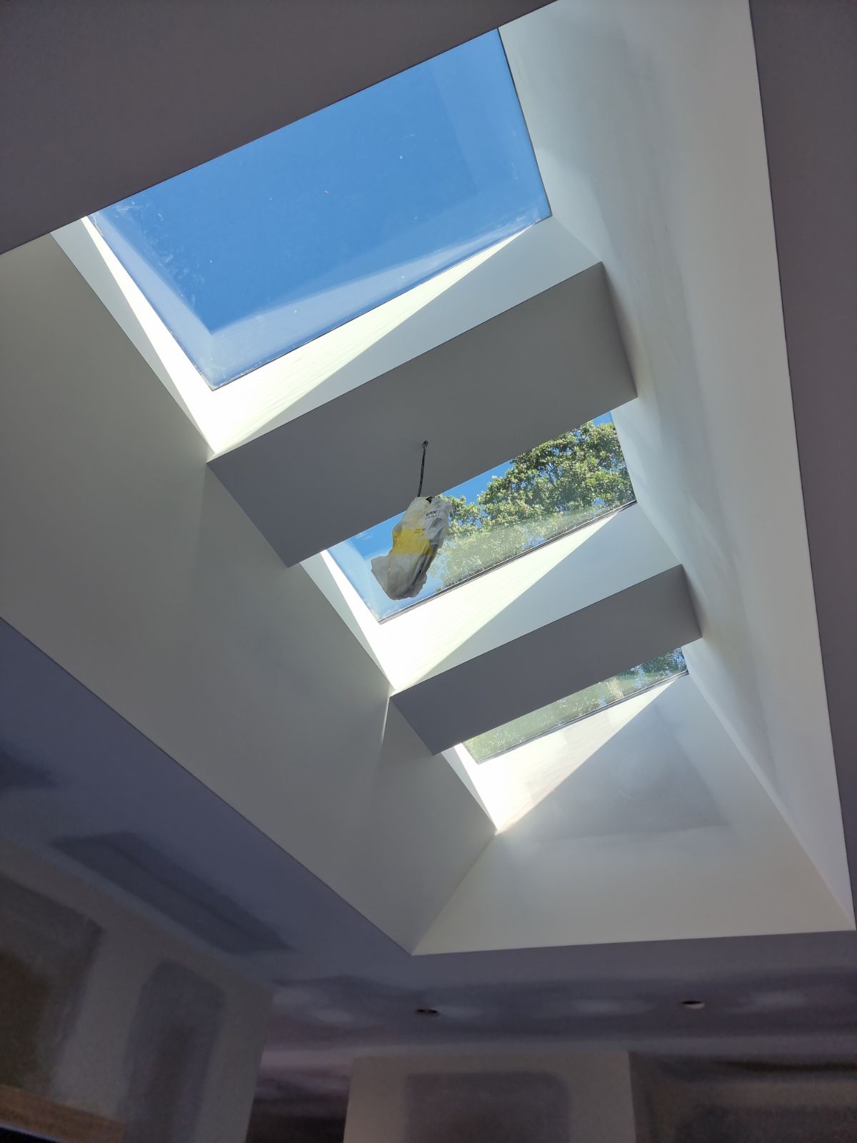 Crisp plastered skylight shaft with sharp returns and clean light across the surfaces